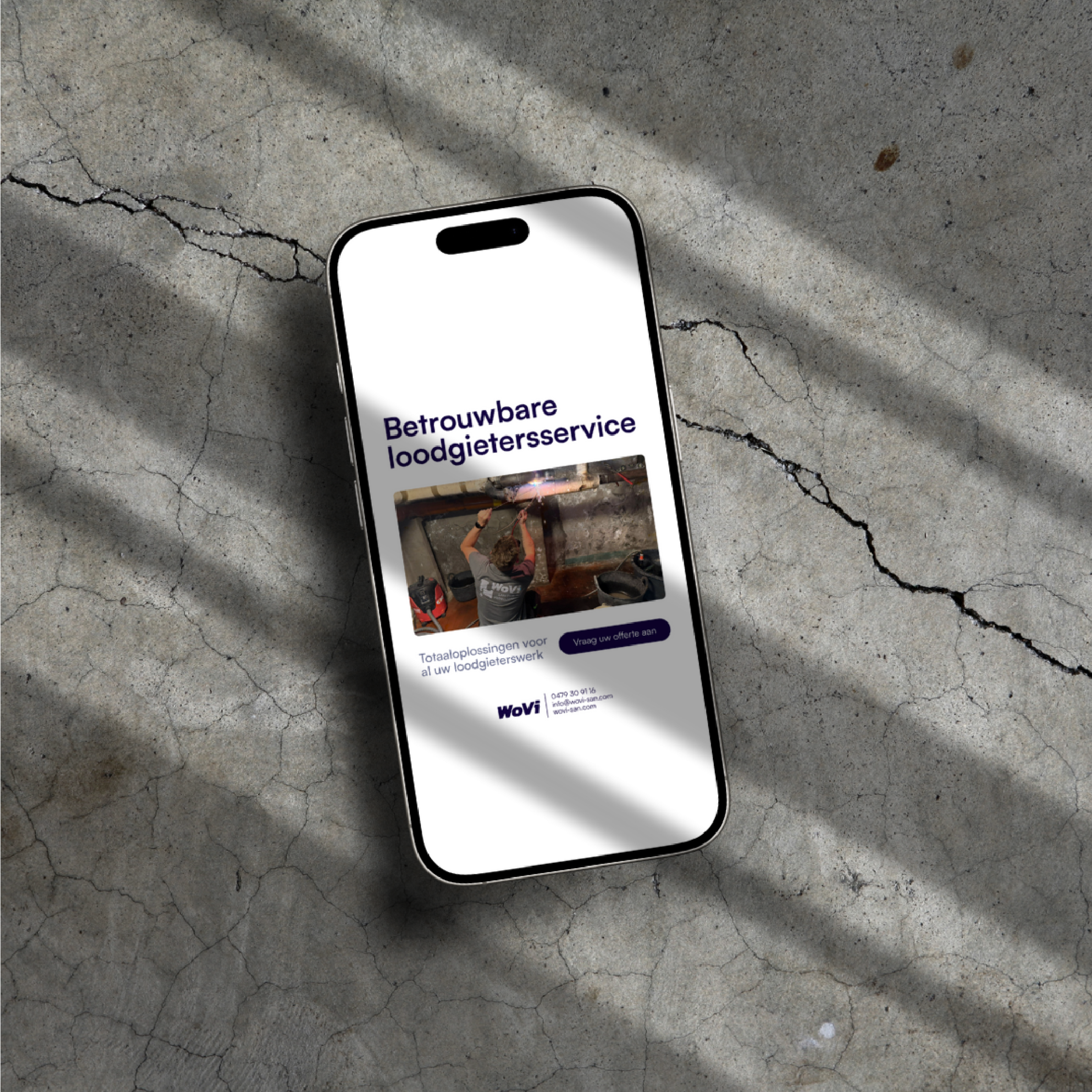 smartphone mockup displaying a Wovi plumbing service advertisement on a concrete background